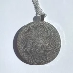 the back of the round flower meadow necklace with a bezel by Julia Tanner