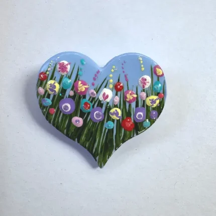 blue heart shaped brooch with a flower meadow by Julia tanner