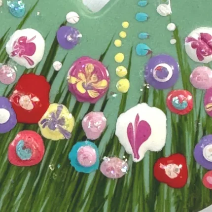 close up of flowers on a turquoise heart shaped flower meadow brooch