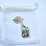 turquoise rectangular necklace with a hand painted flower meadow